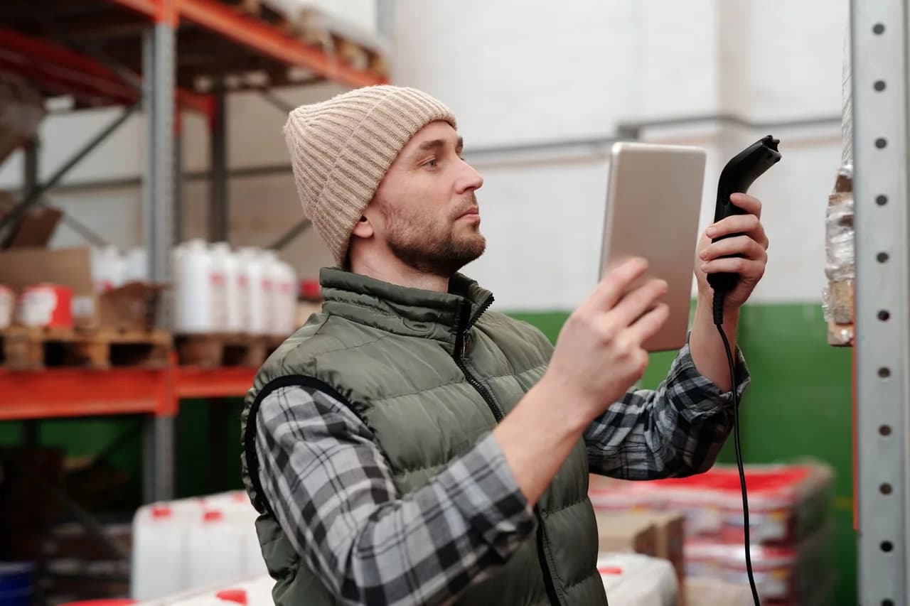 Warehouse operator using a handheld barcode scanner and tablet to record stock movements — a typical high-headcount, single-task Odoo Community deployment